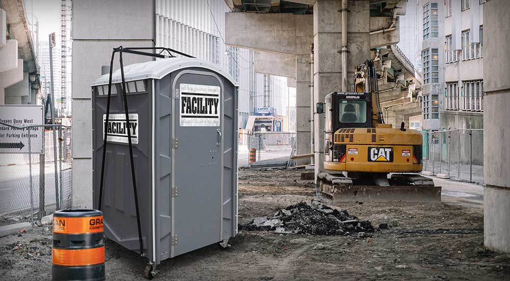 The FACILITY Portable Toilet at a Construction Site Near a Backhoe