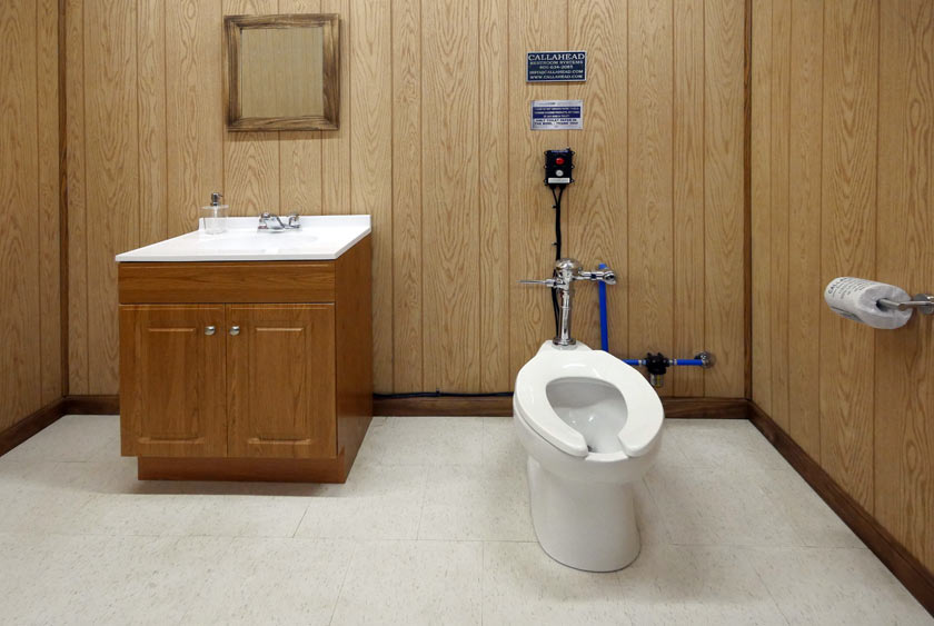 THE WASTE WATER ALARM SHOWN INSIDE A BATHROOM WITH THE COMMERCIAL TOILET SYSTEM