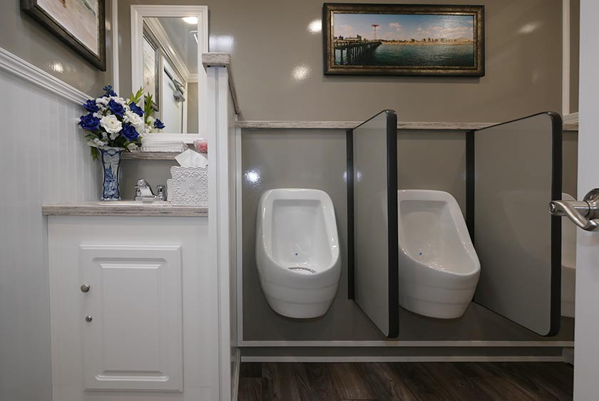 MEN'S RESTROOM HAS ONE VANITY SINK, TWO PRIVATE STALLS AND THREE URINALS