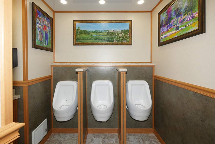 THREE SLOAN PORCELAIN WATERLESS URINALS WITH PRIVACY DIVIDERS AND A CONVENIENCE SHELF ABOVE