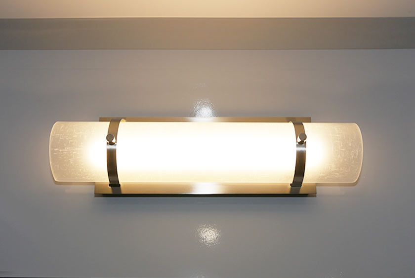 THREE HORIZONTAL LIGHT SCONCES ABOVE VANITY MIRRORS (ONE MEN’S AND TWO WOMEN’S)