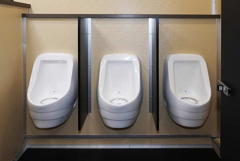 THREE PORCELAIN URINALS ON THE MEN'S 