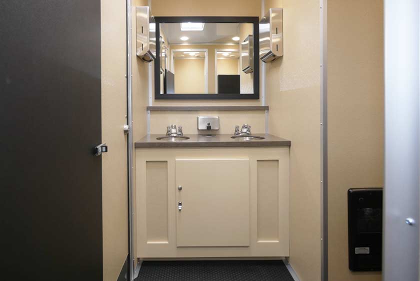 THE WOMENS' SIDE HAS FOUR TOILET STALLS, PLUS DOUBLE SINK VANITY WITH MIRROR AND LI