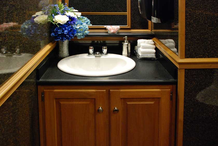 BEAUTIFUL WOOD VANITY AND TRIM THROUGHOUT THE REGENCY LUXURY RESTROOM TRAILER