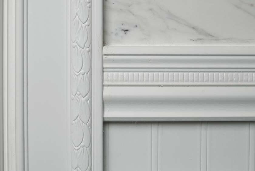 CLOSE UP OF WHITE PAINTED WAINSCOTING WITH CHAIR RAIL AND CASEMENT MOLDING