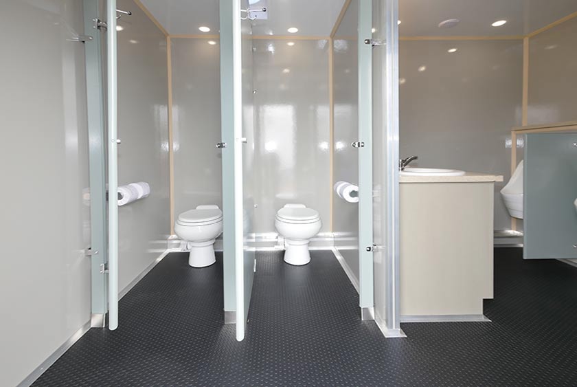 COMFORTABLE TOILET STALLS IN EACH SECTION OF THIS BATHROOM TRAILER