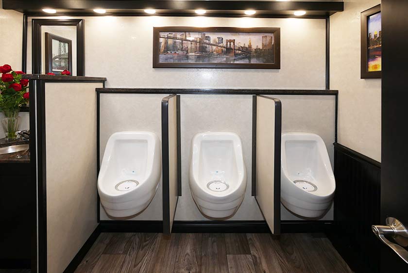 THREE SLOAN PORCELAIN WATERLESS URINALS WITH PRIVACY DIVIDERS